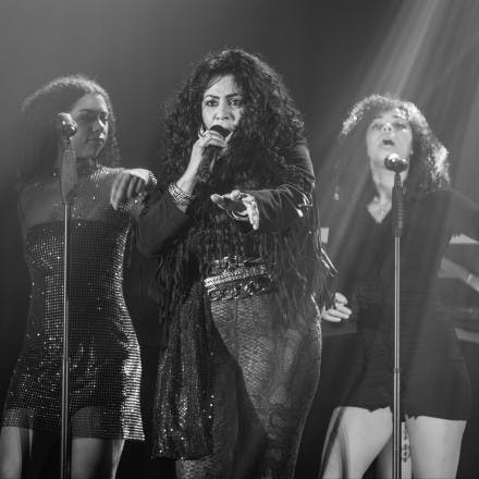 Chaka singing with two backing vocalists behind her.